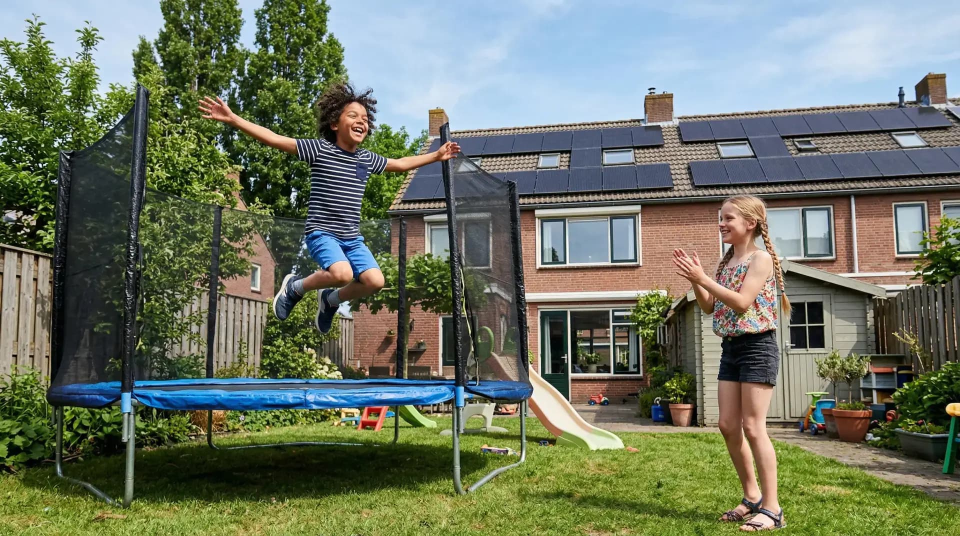 Installateur plaatst power optimizer bij zonnepaneel op dak
