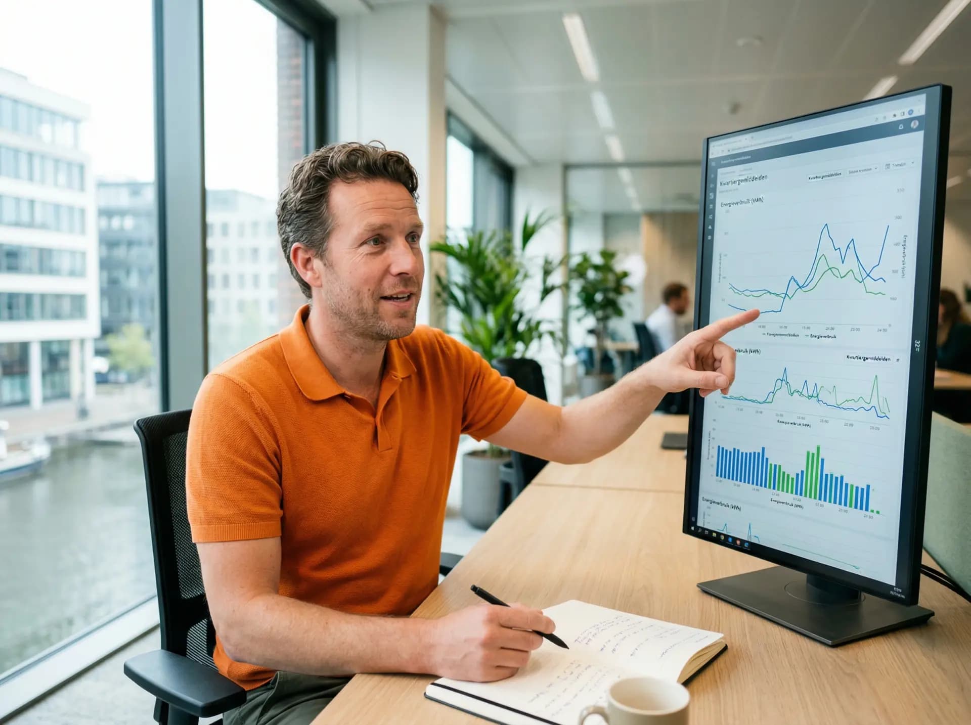 Energieadviseur analyseert kwartierwaarden verbruiksprofiel op scherm in kantoor